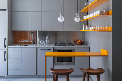 Photo of a small contemporary single-wall open plan kitchen in Los Angeles with a submerged sink, flat-panel cabinets, concrete flooring, grey cabinets, metallic splashback, integrated appliances, composite countertops, grey floors and grey worktops.