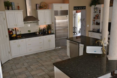 Eat-in kitchen - large transitional l-shaped porcelain tile eat-in kitchen idea in Detroit with a drop-in sink, raised-panel cabinets, yellow cabinets, laminate countertops, white backsplash, cement tile backsplash, stainless steel appliances and two islands