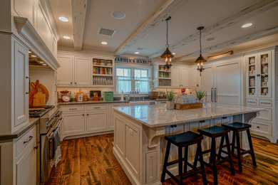 Eat-in kitchen - large country u-shaped brown floor eat-in kitchen idea in Other with a farmhouse sink, beaded inset cabinets, white cabinets, stainless steel appliances and an island