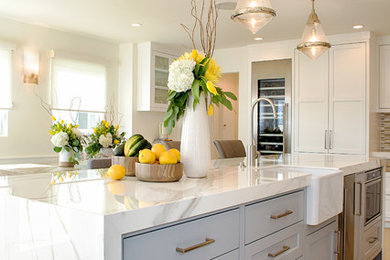 Mid-sized transitional l-shaped porcelain tile and gray floor eat-in kitchen photo in Orange County with a farmhouse sink, shaker cabinets, gray cabinets, quartz countertops, white backsplash, marble backsplash, stainless steel appliances and an island