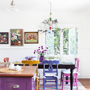 Diseño de cocina en L, romántica, de tamaño medio, con fregadero sobremueble, armarios estilo shaker, puertas de armario blancas, encimera de madera, salpicadero blanco, electrodomésticos de acero inoxidable, suelo de madera en tonos medios y una isla