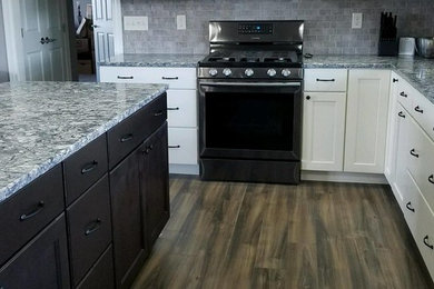Mid-sized elegant l-shaped medium tone wood floor and brown floor eat-in kitchen photo in Chicago with quartz countertops, white cabinets, ceramic backsplash, an island, shaker cabinets and stainless steel appliances