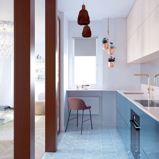 Modern inredning av ett avskilt, mellanstort beige beige l-kök, med en integrerad diskho, släta luckor, bänkskiva i kalksten, stänkskydd med metallisk yta, spegel som stänkskydd, cementgolv och turkost golv
