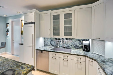 Mid-sized transitional l-shaped ceramic tile kitchen pantry photo in Miami with an undermount sink, recessed-panel cabinets, blue cabinets, quartzite countertops, blue backsplash, stone slab backsplash, paneled appliances and no island