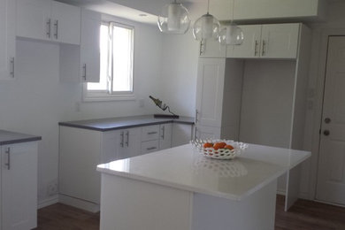 Photo of a contemporary kitchen in Other with shaker cabinets, quartz worktops, light hardwood flooring and an island.