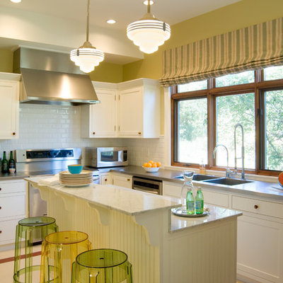 Inspiration for a timeless l-shaped kitchen remodel in Denver with a double-bowl sink, shaker cabinets, white cabinets, white backsplash, subway tile backsplash, stainless steel appliances and an island