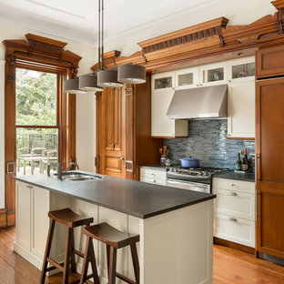 Design ideas for a traditional kitchen in New York with a double-bowl sink, shaker cabinets, beige cabinets, blue splashback, matchstick tile splashback, panelled appliances, medium hardwood floors, with island and grey benchtop.