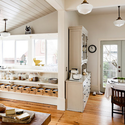 Eat-in kitchen - mid-sized country u-shaped medium tone wood floor and brown floor eat-in kitchen idea in Portland with wood countertops, white backsplash, white appliances, an island and beige countertops