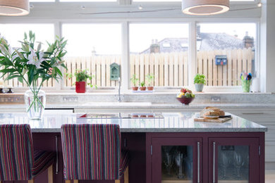 Photo of a farmhouse grey and purple galley kitchen in Other with a built-in sink, glass-front cabinets, purple cabinets, grey splashback, an island and beige floors.