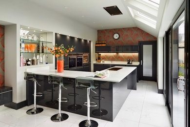 Ejemplo de cocinas en U contemporáneo con armarios con paneles lisos, puertas de armario negras y península