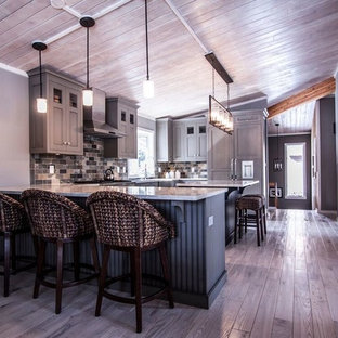 Mid-sized transitional u-shaped eat-in kitchen in Chicago with a farmhouse sink, flat-panel cabinets, green cabinets, quartzite benchtops, multi-coloured splashback, stone tile splashback, panelled appliances, light hardwood floors and with island.