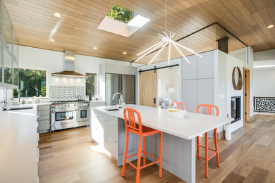 Inspiration for a large contemporary u-shaped light wood floor and brown floor open concept kitchen remodel in Seattle with flat-panel cabinets, gray cabinets, metallic backsplash, stainless steel appliances, an island, an undermount sink, quartz countertops and porcelain backsplash