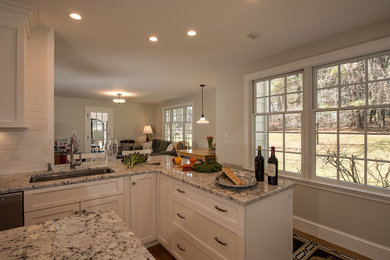 Large l-shaped light wood floor open concept kitchen photo in Boston with an undermount sink, shaker cabinets, white cabinets, granite countertops, white backsplash, subway tile backsplash, stainless steel appliances and an island
