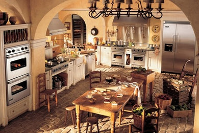 Foto di una cucina abitabile con ante in legno chiaro, elettrodomestici in acciaio inossidabile e nessuna isola