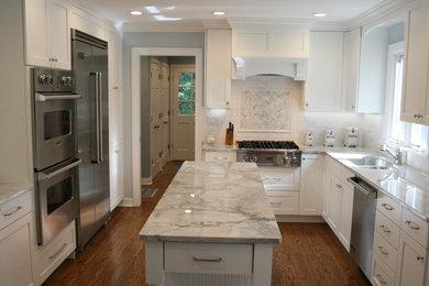 Medium sized traditional l-shaped kitchen/diner in Chicago with a submerged sink, flat-panel cabinets, white cabinets, granite worktops, white splashback, ceramic splashback, stainless steel appliances, medium hardwood flooring and an island.