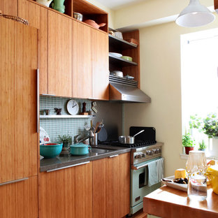 Diseño de cocina bohemia con encimera de piedra caliza, armarios con paneles lisos, puertas de armario de madera oscura, salpicadero azul y electrodomésticos de colores