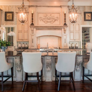 Design ideas for a victorian kitchen in New Orleans with raised-panel cabinets, beige cabinets, panelled appliances, dark hardwood floors and with island.