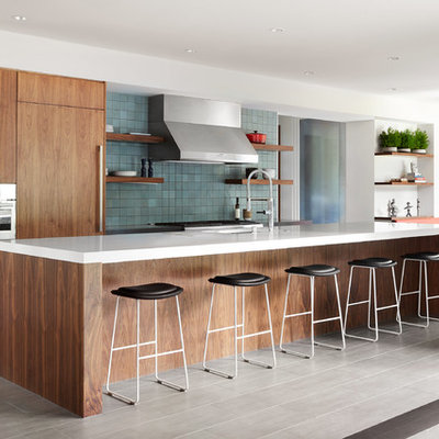 Huge trendy galley porcelain tile and gray floor eat-in kitchen photo in San Francisco with an undermount sink, flat-panel cabinets, quartz countertops, blue backsplash, ceramic backsplash, an island, medium tone wood cabinets, paneled appliances and white countertops