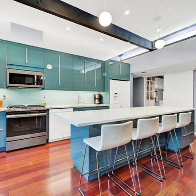 Mid-sized trendy galley medium tone wood floor and brown floor kitchen photo in Sacramento with quartz countertops, glass sheet backsplash, an undermount sink, flat-panel cabinets, green cabinets, green backsplash, white appliances and an island