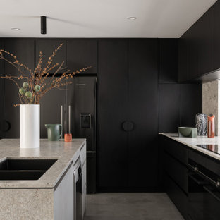 Inspiration for a large modern l-shaped kitchen in Perth with an undermount sink, black cabinets, granite benchtops, window splashback, black appliances, concrete floors, with island, grey floor, grey benchtop and flat-panel cabinets.