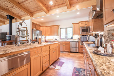 Open concept kitchen - large transitional u-shaped light wood floor and beige floor open concept kitchen idea in Other with an undermount sink, shaker cabinets, light wood cabinets, granite countertops, stainless steel appliances, an island and brown countertops