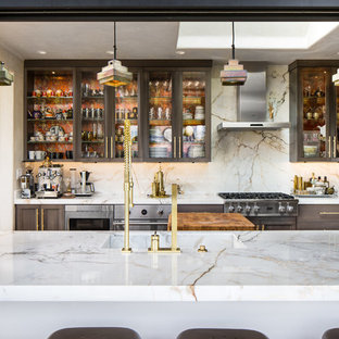 Photo of a large eclectic u-shaped eat-in kitchen in San Francisco with a drop-in sink, glass-front cabinets, grey cabinets, marble benchtops, white splashback, stone slab splashback, stainless steel appliances, terra-cotta floors and with island.