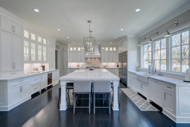 Huge transitional u-shaped dark wood floor and black floor eat-in kitchen photo in Atlanta with a farmhouse sink, beaded inset cabinets, white cabinets, quartz countertops, white backsplash, quartz backsplash, stainless steel appliances, an island and white countertops