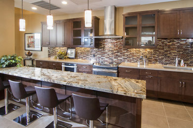 Foto di una grande cucina minimal con ante con riquadro incassato, ante in legno bruno, top in marmo, paraspruzzi marrone, paraspruzzi con piastrelle a mosaico e elettrodomestici in acciaio inossidabile