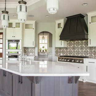 Large transitional open concept kitchen pictures - Example of a large transitional l-shaped dark wood floor and brown floor open concept kitchen design in Minneapolis with a farmhouse sink, shaker cabinets, white cabinets, quartz countertops, multicolored backsplash, cement tile backsplash, paneled appliances and an island