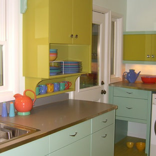 Inspiration for a mid-sized midcentury galley separate kitchen in Portland with a drop-in sink, flat-panel cabinets, green cabinets, laminate benchtops, metallic splashback, stainless steel appliances, vinyl floors and no island.