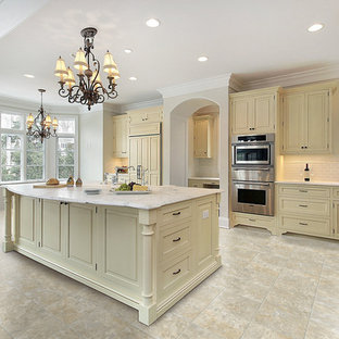 Inspiration for a large traditional l-shaped eat-in kitchen in Miami with raised-panel cabinets, white splashback, subway tile splashback, stainless steel appliances, vinyl floors, with island, beige cabinets and marble benchtops.