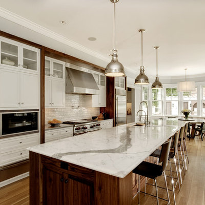 Inspiration for a contemporary kitchen remodel in New York with white cabinets, beige backsplash, matchstick tile backsplash and stainless steel appliances