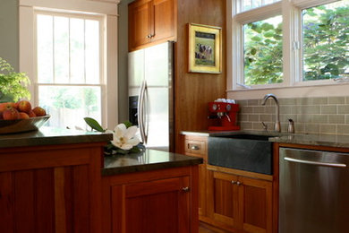 Inspiration for a mid-sized craftsman galley medium tone wood floor eat-in kitchen remodel in Atlanta with a farmhouse sink, recessed-panel cabinets, medium tone wood cabinets, granite countertops, green backsplash, ceramic backsplash, stainless steel appliances and an island