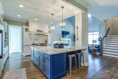 Inspiration for a large contemporary dark wood floor eat-in kitchen remodel in Other with a farmhouse sink, blue cabinets, white backsplash, stainless steel appliances, an island and gray countertops