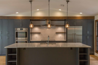 Example of a large classic single-wall light wood floor open concept kitchen design in Miami with a single-bowl sink, recessed-panel cabinets, gray cabinets, marble countertops, white backsplash, subway tile backsplash, stainless steel appliances and an island