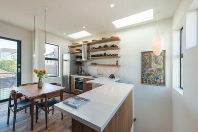 Small trendy l-shaped dark wood floor eat-in kitchen photo in Los Angeles with an undermount sink, flat-panel cabinets, medium tone wood cabinets, quartz countertops, white backsplash, ceramic backsplash, stainless steel appliances and no island
