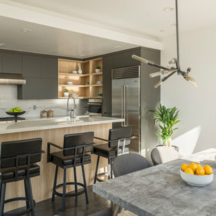 Contemporary eat-in kitchen designs - Eat-in kitchen - contemporary l-shaped gray floor eat-in kitchen idea in Los Angeles with flat-panel cabinets, gray cabinets, stainless steel appliances, an island and white countertops
