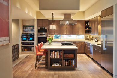 Example of a large trendy l-shaped medium tone wood floor open concept kitchen design in Seattle with an undermount sink, flat-panel cabinets, dark wood cabinets, quartz countertops, brown backsplash, glass tile backsplash, stainless steel appliances and an island