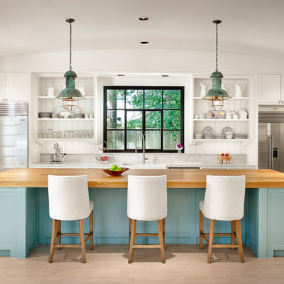 Inspiration for a large coastal u-shaped light wood floor kitchen remodel in Houston with an island, white cabinets, marble countertops, stainless steel appliances, open cabinets, a farmhouse sink, white backsplash and wood backsplash