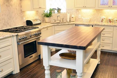 Eat-in kitchen - large country u-shaped ceramic tile eat-in kitchen idea in Dallas with an undermount sink, recessed-panel cabinets, white cabinets, granite countertops, multicolored backsplash, ceramic backsplash, stainless steel appliances and an island