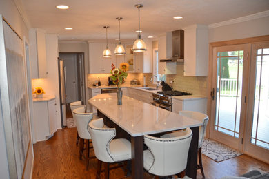 Example of a l-shaped medium tone wood floor kitchen design in Cleveland with an undermount sink, shaker cabinets, white cabinets, quartzite countertops, white backsplash, subway tile backsplash, stainless steel appliances, an island and white countertops