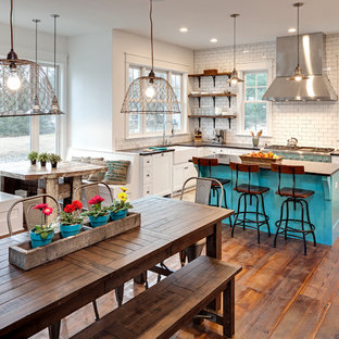 Example of an eclectic dark wood floor kitchen design in Chicago with a farmhouse sink, recessed-panel cabinets, white cabinets, white backsplash, subway tile backsplash, stainless steel appliances and an island