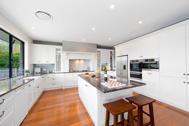 シドニーにあるトラディショナルスタイルのおしゃれなキッチン (エプロンフロントシンク、シェーカースタイル扉のキャビネット、白いキャビネット、御影石カウンター、白いキッチンパネル、サブウェイタイルのキッチンパネル、シルバーの調理設備) の写真