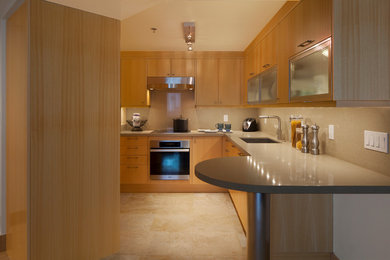 Example of a mid-sized trendy u-shaped porcelain tile and beige floor enclosed kitchen design in Hawaii with an undermount sink, flat-panel cabinets, light wood cabinets, quartz countertops and stainless steel appliances
