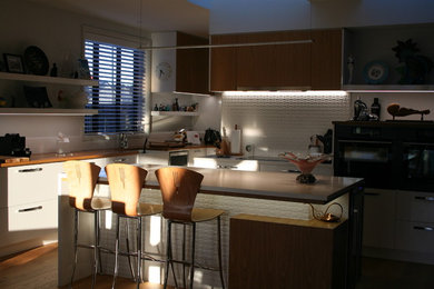 Imagen de cocinas en L contemporánea abierta con salpicadero blanco, salpicadero de azulejos de cerámica, suelo de madera clara, una isla y suelo marrón