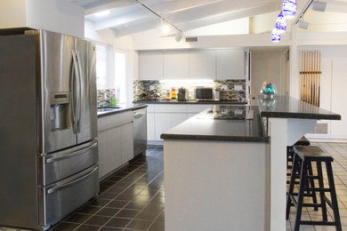 Imagen de cocina actual con electrodomésticos de acero inoxidable, salpicadero con mosaicos de azulejos y fregadero bajoencimera