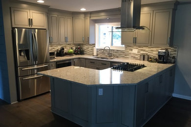 Example of a mid-sized transitional u-shaped dark wood floor eat-in kitchen design in Detroit with an undermount sink, shaker cabinets, gray cabinets, quartz countertops, gray backsplash, mosaic tile backsplash, stainless steel appliances and no island