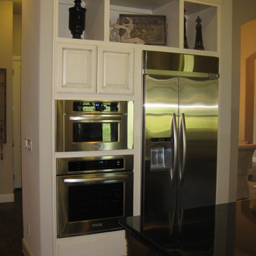 wall ovens next to refrigerator in kitchen by Burrows Cabinets