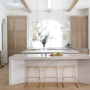 Mediterranean kitchen designs - Example of a tuscan light wood floor kitchen design in Austin with an undermount sink, shaker cabinets, light wood cabinets, stainless steel appliances, two islands and white countertops