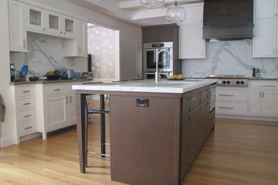 Inspiration for a large contemporary u-shaped light wood floor and beige floor open concept kitchen remodel in San Francisco with an undermount sink, shaker cabinets, white cabinets, marble countertops, white backsplash, marble backsplash, paneled appliances, an island and white countertops